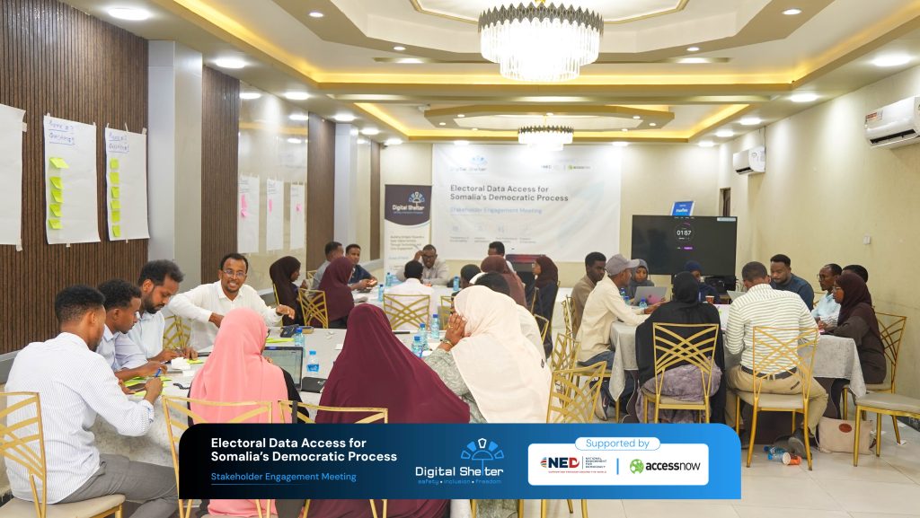Participants seated at tables in small groups, in discussion during the stakeholder meeting